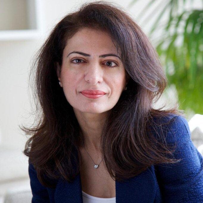 Portrait of Dr. Amina AlRostamani in formal attire, representing her leadership in technology and business.