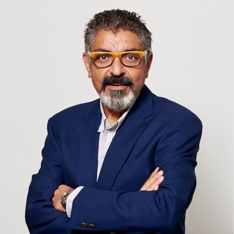 Portrait of Shuja Jashanmal in formal attire, symbolizing his successful rise from salesman to executive leader in retail.